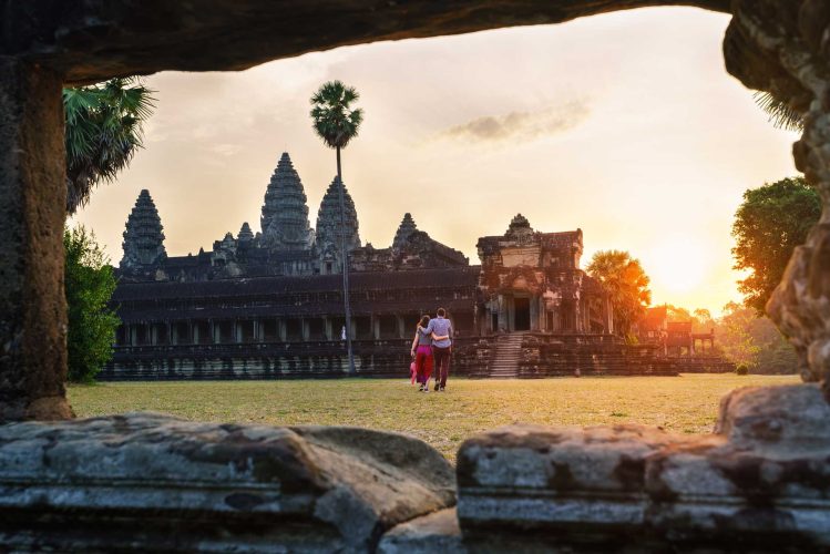 Travel couple in Angkor Wat at sunrise moment, Siem Reap, Cambodia